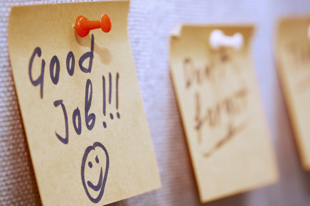 Sticky note with “Good Job!!!” written on it, symbolizing the vague, unhelpful feedback often associated with traditional performance reviews.