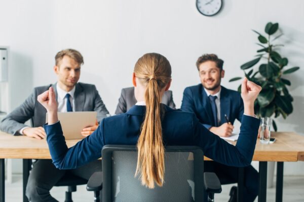 Woman meeting with a panel of professionals, symbolizing HR consultation, tailored recommendations, implementation support, and ongoing partnership.
