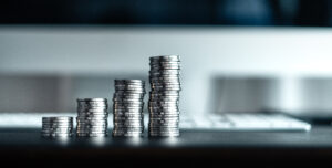 Stacks of coins increasing in height, symbolizing how outsourcing HR saves time, reduces risk, and boosts compliance while maximizing business value.