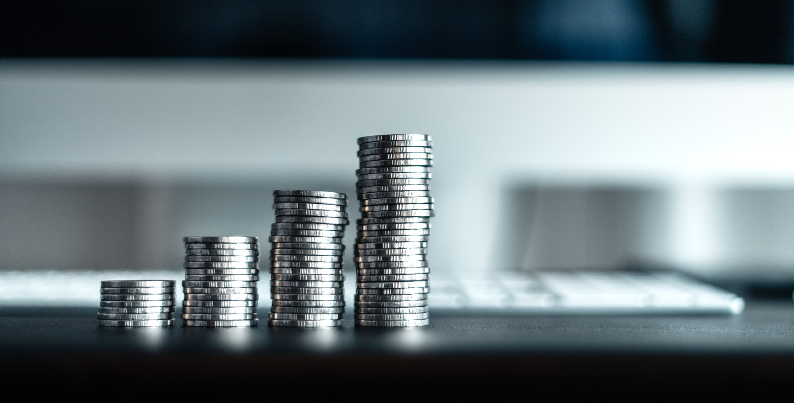 Stacks of coins increasing in height, symbolizing how outsourcing HR saves time, reduces risk, and boosts compliance while maximizing business value.