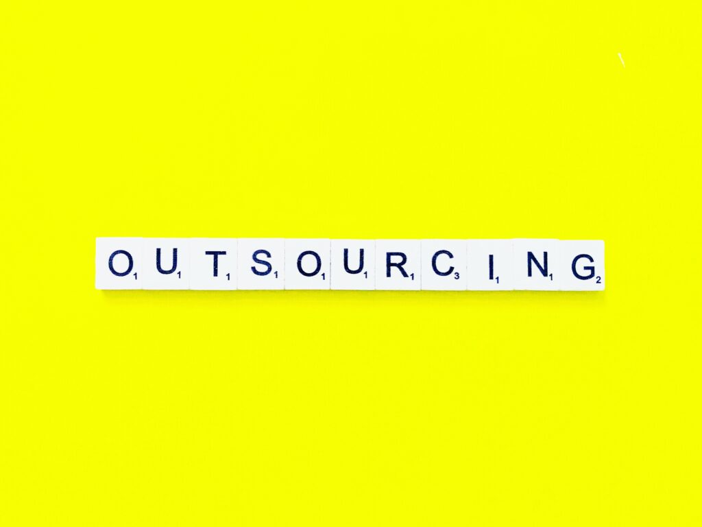 Scrabble-style tiles spelling “Outsourcing,” representing how outsourced HR strengthens operations, minimizes compliance risks, and builds scalable, efficient HR systems.